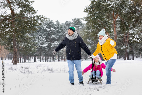 Tablou pe pânză Little girl with her grandparents sledging on snowy winter day