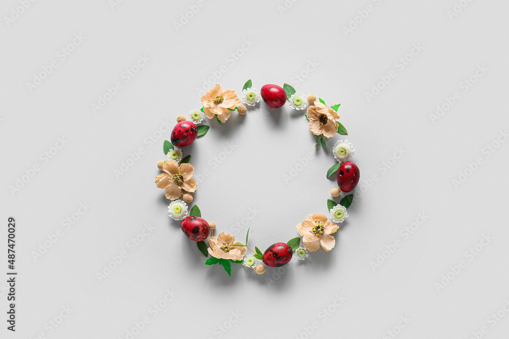 Beautiful wreath with Easter eggs and flowers on light background Beautiful wreath with Easter eggs and flowers on light background