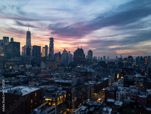 Fototapet New York City skyline lights at dusk with colorful sky above the buildings of Lo