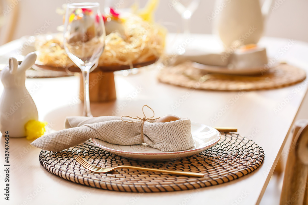 Plate with Easter egg and napkin on served dining table Plate with Easter egg and napkin on served dining table