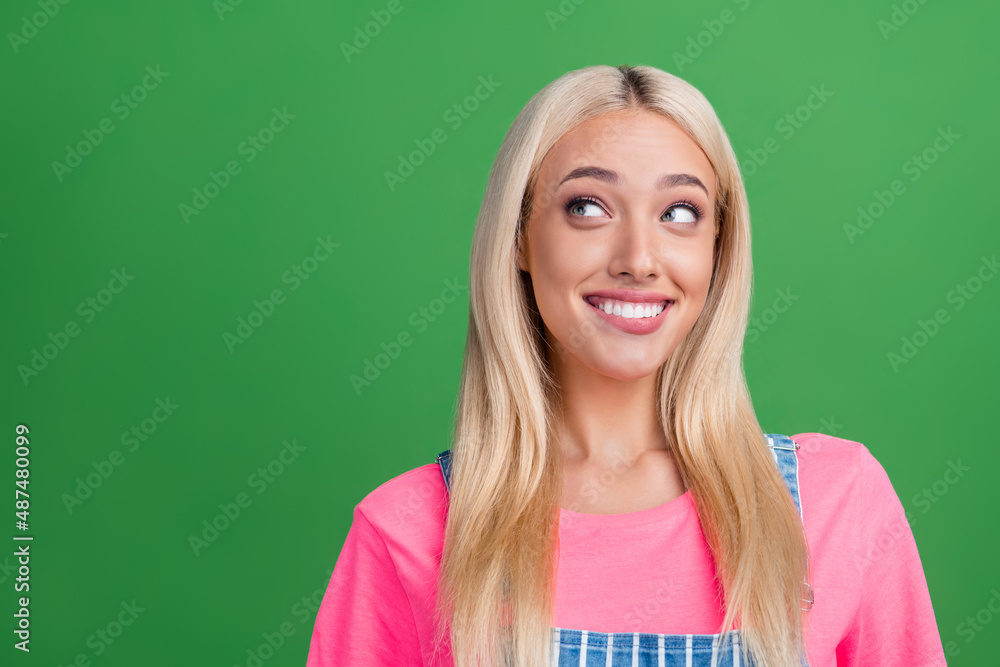 Photo of cute lovely positive lady look empty space shiny smile wear striped overall isolated green color background Photo of cute lovely positive lady look empty space shiny smile wear striped overall isolated green color background