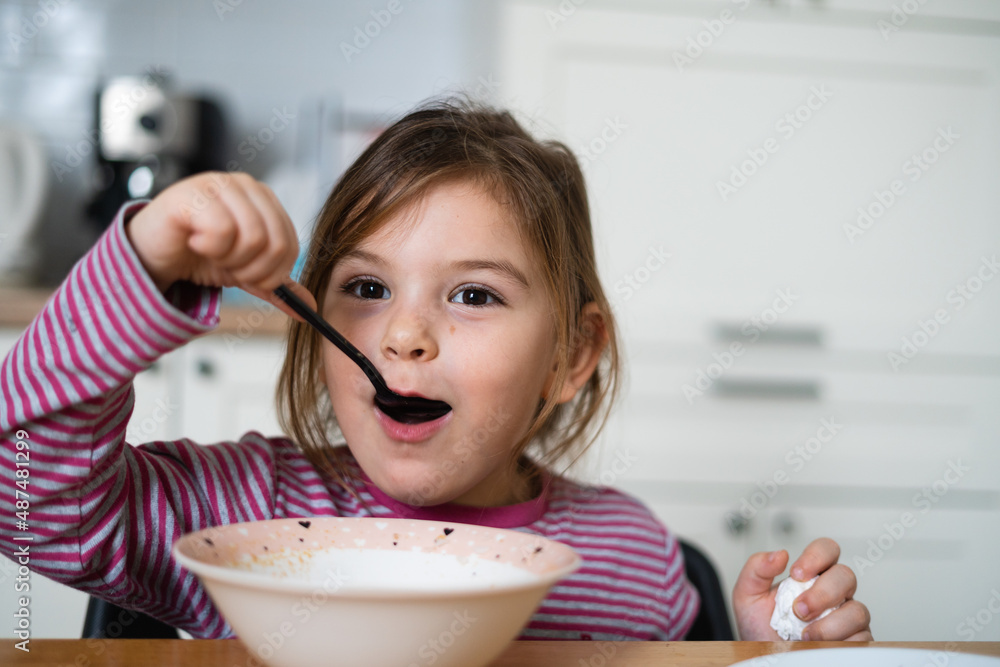 Close up of preschool girl portrait with funny expression eating soup at home Close up of preschool girl portrait with funny expression eating soup at home