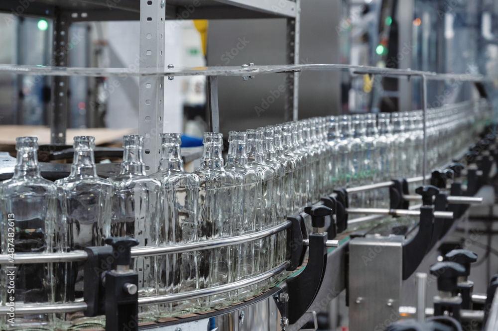 Long row of empty glass bottles for alcohol drinks at plant