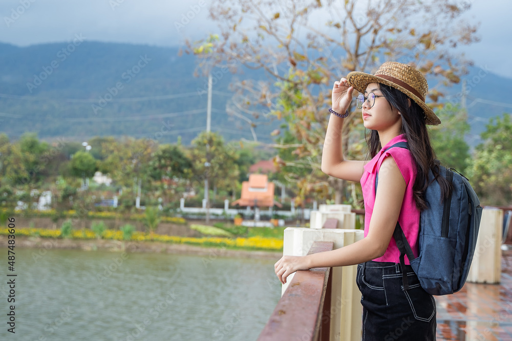 Young traveler woman in summer vacation wearing straw hat, enjoying the view at the landscape.
