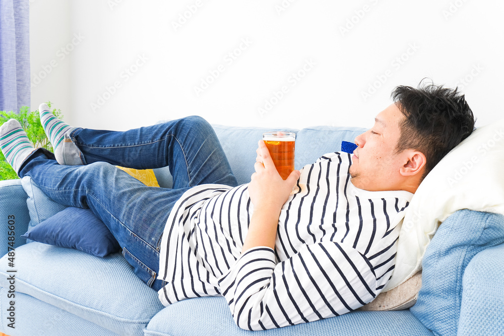 自宅でビールを飲む中年の男性 自宅でビールを飲む中年の男性