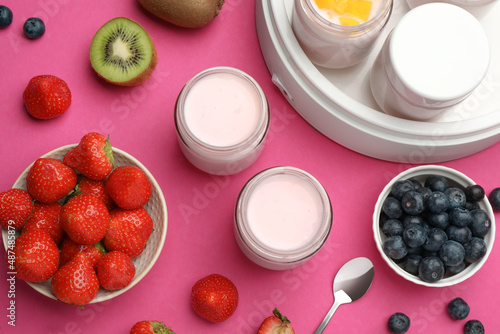 Yogurt maker with jars and different fruits on pink background, flat lay