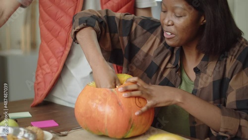 A handsome young lady is carving the pumpkin