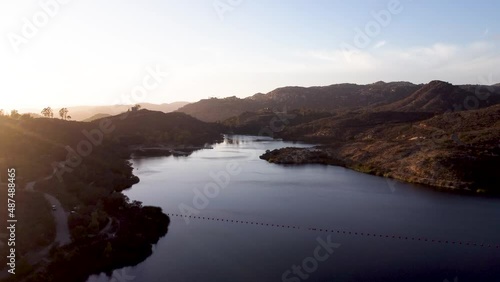 A beautiful aerial shot with a drone flying over Dixon Lake with crystal clear water during golden hour in Escondido, California photo