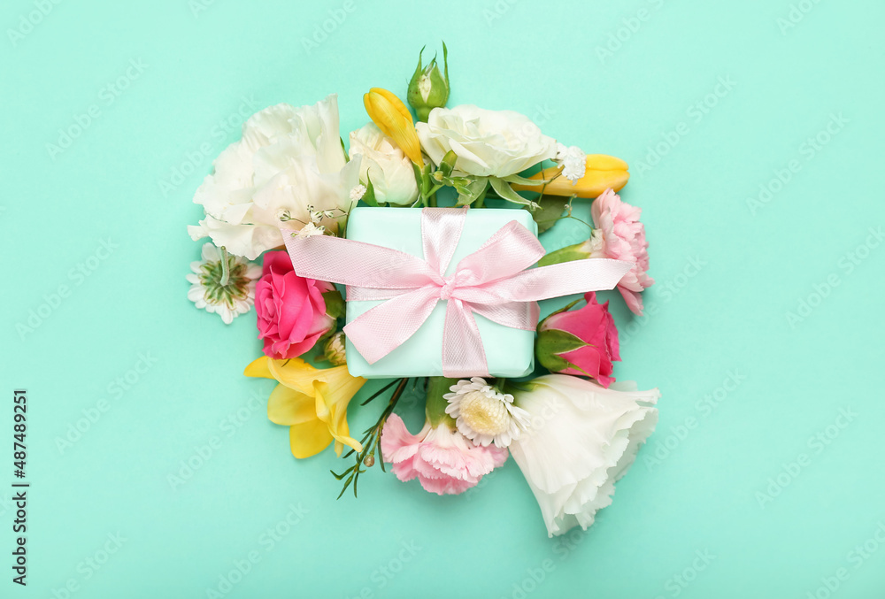 Beautiful spring composition with flowers and gift box on green background Beautiful spring composition with flowers and gift box on green background