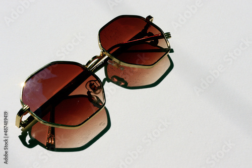 close up of golden frame sun glass with reflection and isolated white background