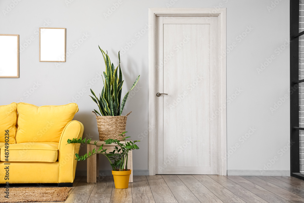 © Pixel-Shot - Wooden table with houseplants and yellow sofa near light wall © Pixel-Shot - Wooden table with houseplants and yellow sofa near light wall