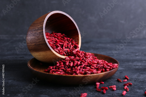 Tableau sur toile Bowl and plate with dried barberries on dark background