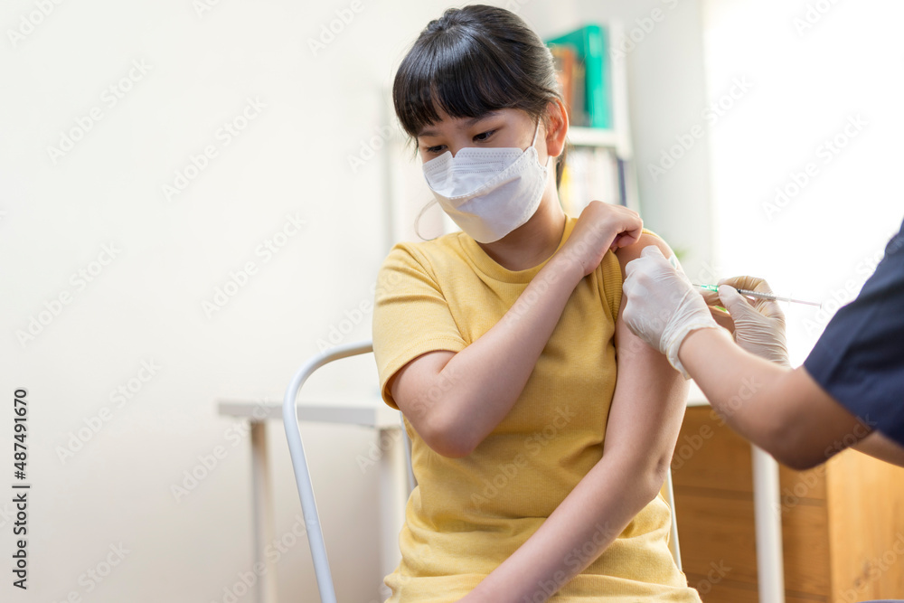 Japanese Preteen Girl Getting Vaccinated, Receiving Coronavirus Vaccine Injection in clinic.