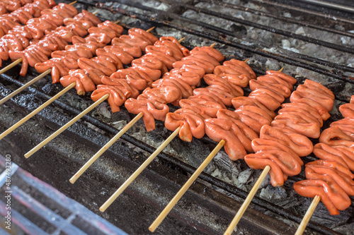Rows of Isaw or chicken intestine on sticks being cooked on the grill. Isaw is a Filipino delicacy. photo