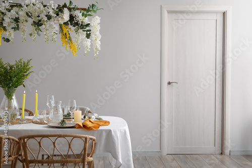 Stylish table setting with beautiful flowers in dining room