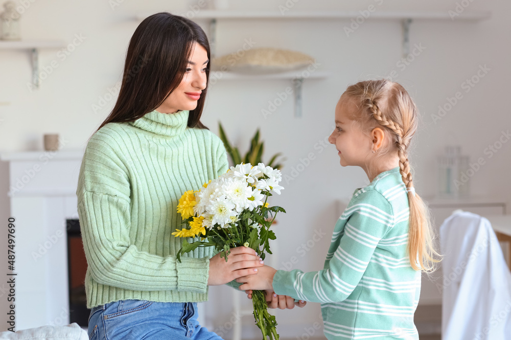 Little girl greeting her mother with flowers at home Little girl greeting her mother with flowers at home