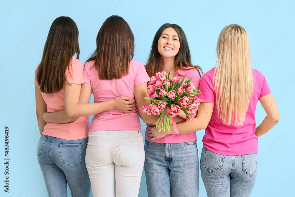 Beautiful women with bouquet of flowers on blue background. International Women's Day celebration Beautiful women with bouquet of flowers on blue background. International Women's Day celebration
