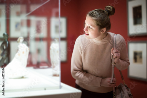 Positive female in the historical museum looking at art object.