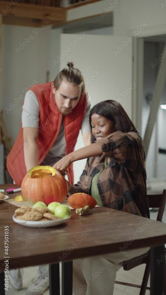 A handsome young lady is carving the pumpkin A handsome young lady is carving the pumpkin