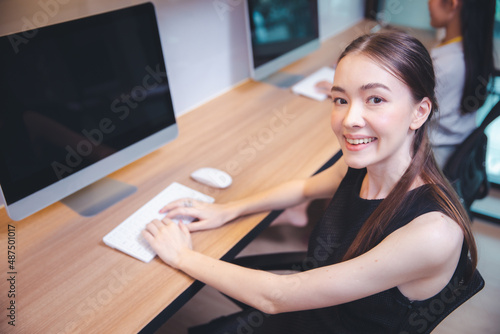 Young beautiful female smiling working with computer desktop at modern office