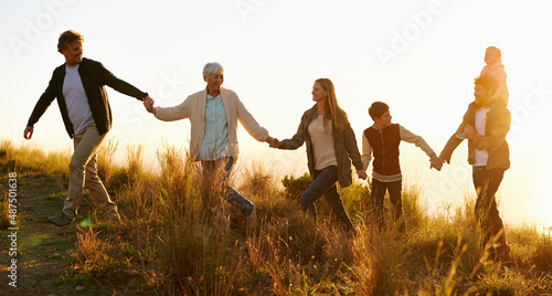 The hills are alive. Shot of a happy family holding hands on a morning walk together.