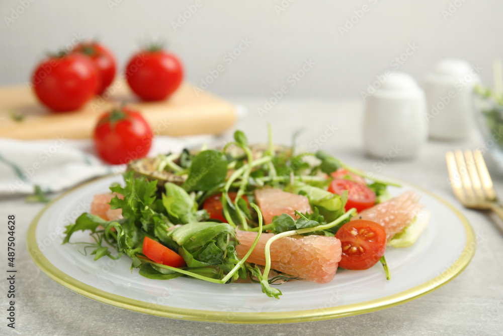 Delicious pomelo salad served on light grey table, closeup