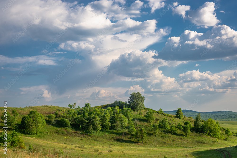 Obraz premium Thick clouds and green trees on the hills.
