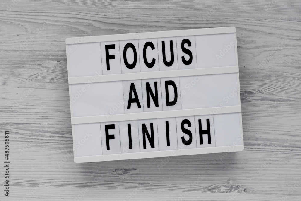 'Focus and Finish' on a lightbox on a white wooden surface, top view. Flat lay, overhead, from above. 'Focus and Finish' on a lightbox on a white wooden surface, top view. Flat lay, overhead, from above.