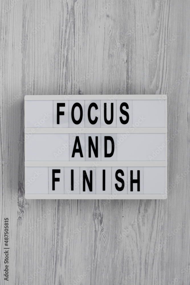 'Focus and Finish' on a lightbox on a white wooden surface, top view. Flat lay, overhead, from above. 'Focus and Finish' on a lightbox on a white wooden surface, top view. Flat lay, overhead, from above.