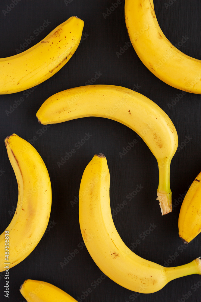 Raw Organic Bananas on black background, overhead view. Flat lay, top view, from above.