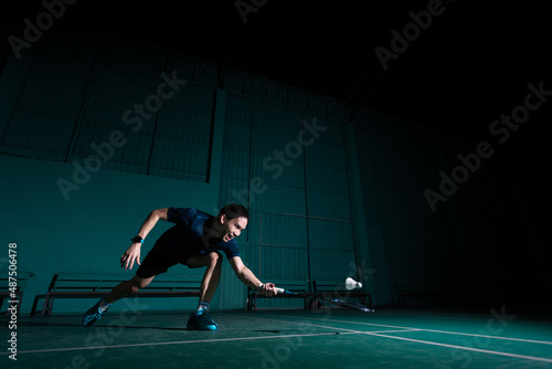 professional badminton player use racquet hit shuttle cock or shuttlecock on court during warm up play before tournament competition in single man type in indoor court