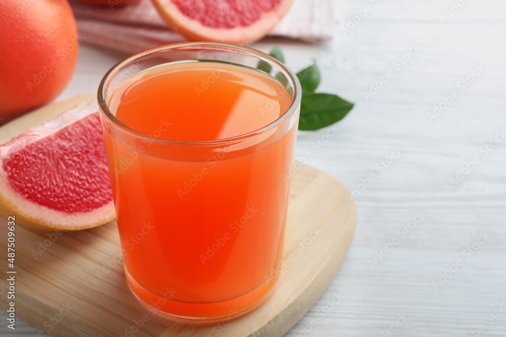 Tasty freshly made grapefruit juice on white wooden table. Space for text Tasty freshly made grapefruit juice on white wooden table. Space for text