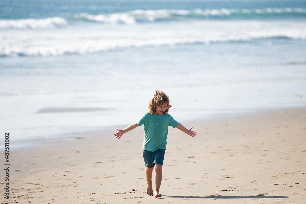Child boy walk to sea beach, raised hands. Amazed surprised kids emotions.