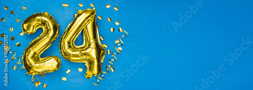 golden foil balloon number twenty four. Birthday or anniversary card with the inscription 24. blue concrete background. Anniversary celebration. Banner. photo