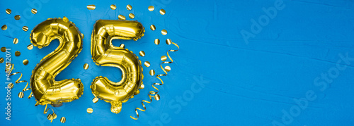 golden foil balloon number twenty five. Birthday or anniversary card with the inscription 25. blue concrete background. Anniversary celebration. Banner. photo