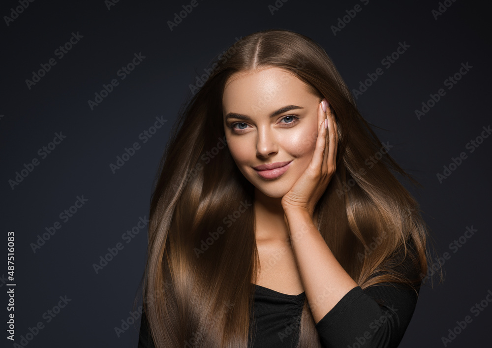 © Utkamandarinka - Beautiful brunette woman in black dress long beauty smooth hair touching her face Gray background