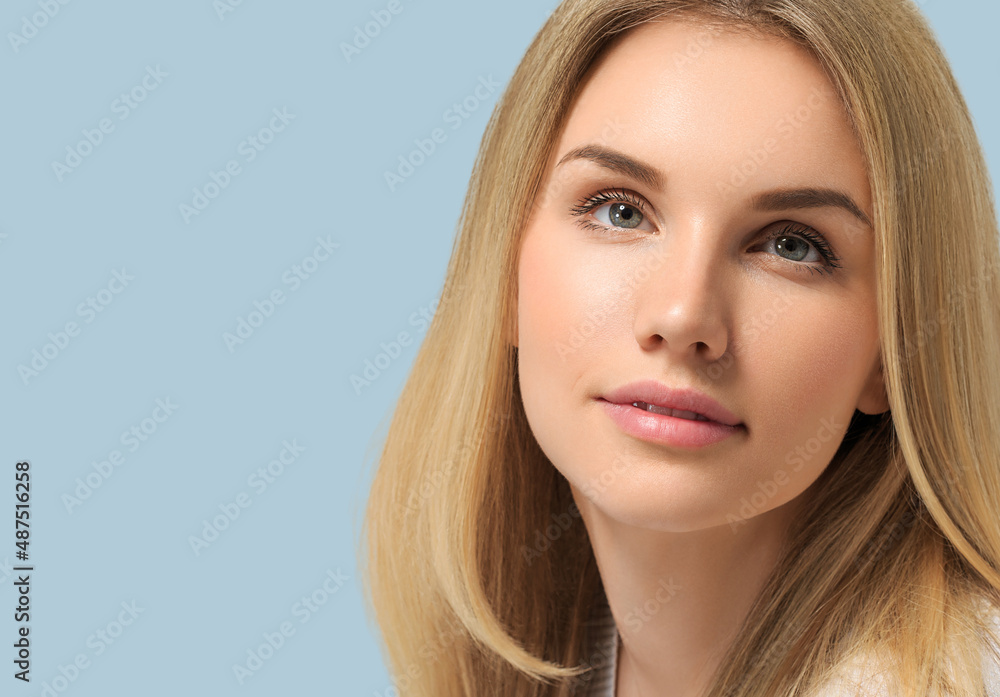 Long smooth blonde hairstyle beauty woman close up portrait. Color background blue