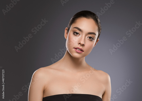 Beautiful freckles woman brunette hair concept portrait healthy skin. Color background gray