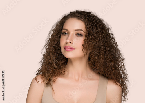 Curly long brunette hair woman beauty portrait, female glamour face. Color backgound pink