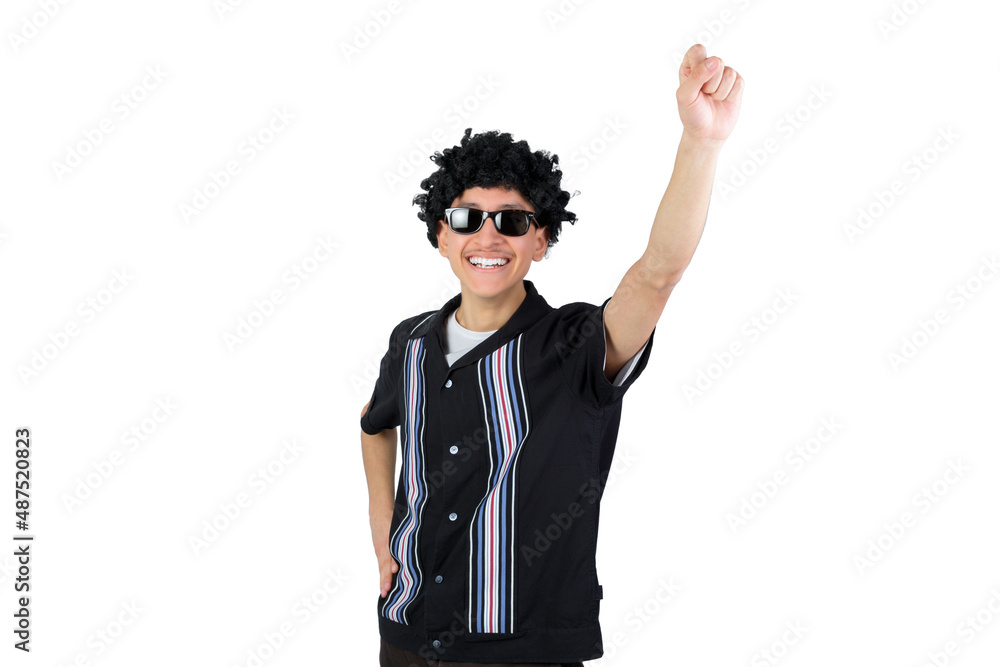 Happy guy raising fist, smiling looking at camera. Wearing an afro wig and sunglasses. Isolated on white background. Latin 18-20 years old guy. Happy guy raising fist, smiling looking at camera. Wearing an afro wig and sunglasses. Isolated on white background. Latin 18-20 years old guy.