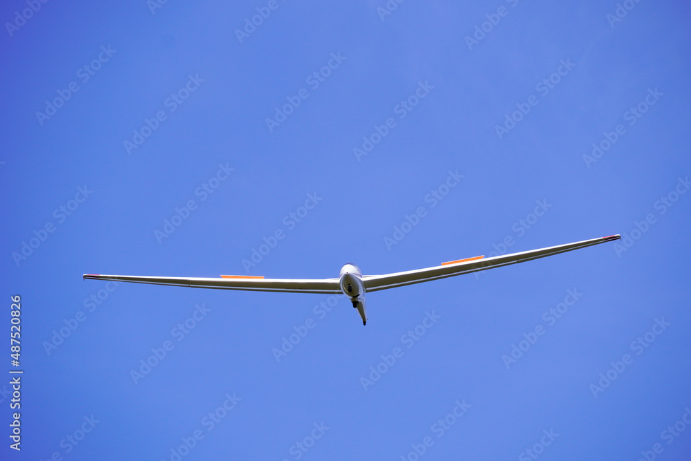 White glider with blue cloudless sky in the background. Aircraft for gliding. White glider with blue cloudless sky in the background. Aircraft for gliding.