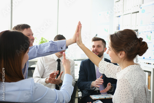 Colleagues give high five gesture in order to celebrate end of company project