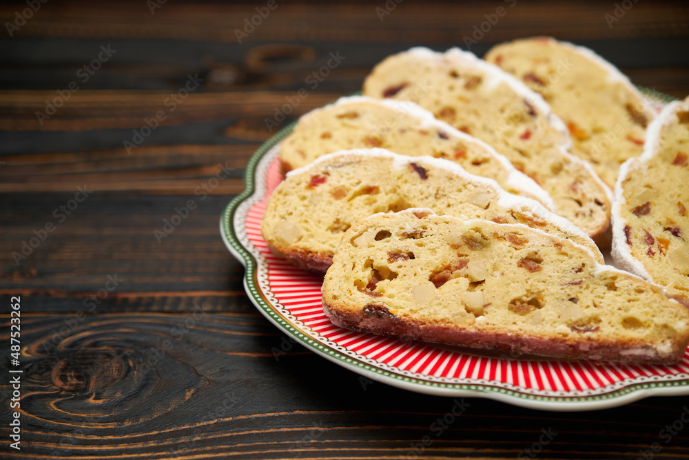 Slices of Traditional Christmas stollen cake with marzipan and dried fruit on wooden background Slices of Traditional Christmas stollen cake with marzipan and dried fruit on wooden background