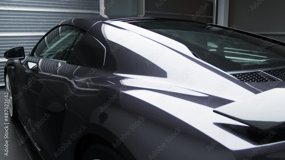 Lights Reflect On Sleek Body Of A New Car Parked In The Showroom. - side view, close up Lights Reflect On Sleek Body Of A New Car Parked In The Showroom. - side view, close up