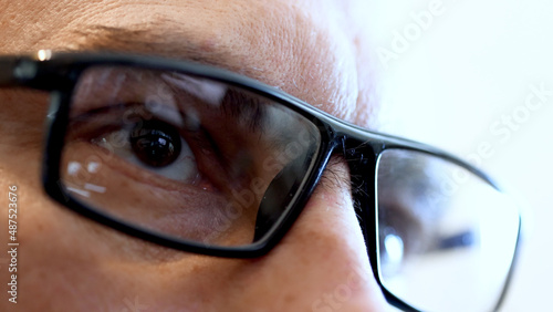 Face and reflection of the tablet screen in glasses.