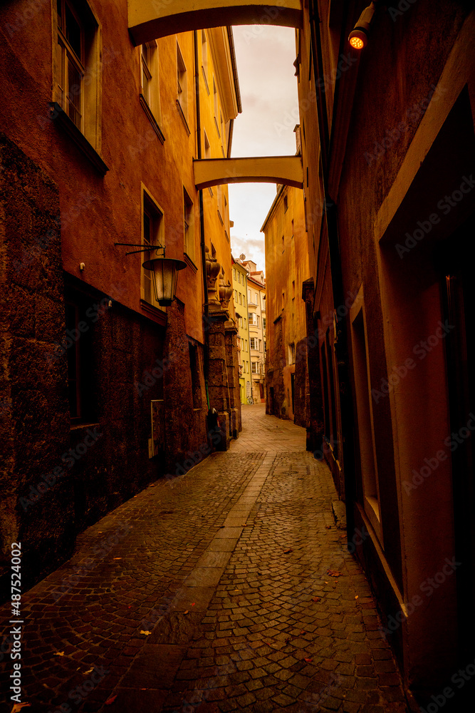 Gloomy narrow long antique street with a stone path in europe. Beautiful old architecture.