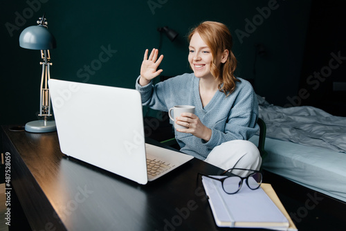 Young woman having video call on her computer at the hottel room. photo