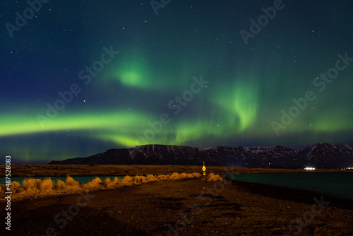 Polarlichter über der Halbinsel Geldinganes mit Blick auf den Gebirgszug Esja nahe Reykjvik photo