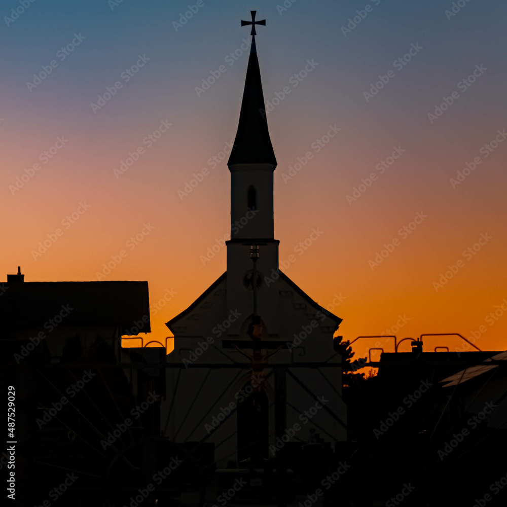 Fototapeta premium Beautiful sunset with a church silhouette at Eichendorf, Bavaria, Germany