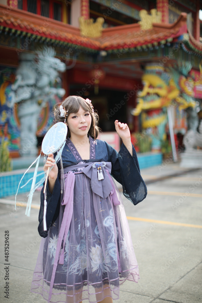 Obraz premium Beautiful young woman with dark blue Chinese lolita dress with Chinese garden